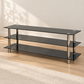 Black tempered glass and chrome 60-inch TV stand in a warm living room, with no TV