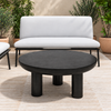 Rocca black round coffee table with three cylindrical legs, centred in a patio lifestyle setting